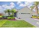 One-story house with a two-car garage, palm trees and landscaping at 5752 Whispering Oaks Dr., North Port, FL 34287