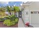 Front entrance of a house with walkway, landscaping, and a two-car garage at 5752 Whispering Oaks Dr., North Port, FL 34287