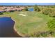 Aerial view of a golf course with water features and players at 5752 Whispering Oaks Dr., North Port, FL 34287