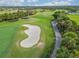 Aerial view of a golf course with sand traps and lush green fairways at 5752 Whispering Oaks Dr., North Port, FL 34287