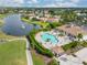 Community pool with surrounding lounge chairs and clubhouse at 5752 Whispering Oaks Dr., North Port, FL 34287