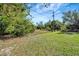 Spacious backyard with grassy area and mature trees at 6174 Alloway St, Englewood, FL 34224