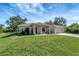 Tan house with a two-car garage, covered porch and well-manicured lawn at 6174 Alloway St, Englewood, FL 34224