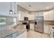 Modern kitchen with white cabinets, granite countertops, and stainless steel appliances at 6174 Alloway St, Englewood, FL 34224