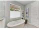 Relaxing bathroom with oval-shaped soaking tub and window at 668 W Olympia Ave, Punta Gorda, FL 33950