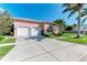 Pink house with two-car garage and landscaped yard at 668 W Olympia Ave, Punta Gorda, FL 33950