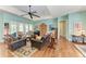 Bright living room with hardwood floors, leather furniture, and a ceiling fan at 668 W Olympia Ave, Punta Gorda, FL 33950