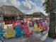 Beach bar with colorful chairs and thatch-roofed cabanas at 8773 Tuscany Isles Dr, Punta Gorda, FL 33950