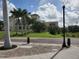 Exterior view of a community building with palm trees and walking path at 8773 Tuscany Isles Dr, Punta Gorda, FL 33950