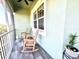 Peaceful screened balcony with rocking chairs, offering tranquil nature views at 10320 Lands End Cir # 47, Placida, FL 33946