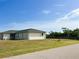 Side view of a single-story house with a grassy yard at 12143 & 12151 Dubarry Ave, Port Charlotte, FL 33981