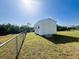 White metal storage shed in a grassy yard at 12143 & 12151 Dubarry Ave, Port Charlotte, FL 33981