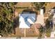 Aerial view of a single-Gathering home with a metal roof, paved driveway, and landscaped yard at 13204 Kakapo Ave, Port Charlotte, FL 33981