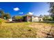 Charming yellow house with metal roof, screened patio, and large backyard at 13204 Kakapo Ave, Port Charlotte, FL 33981