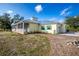 Side view of a yellow house with metal roof, garage, and landscaping at 13204 Kakapo Ave, Port Charlotte, FL 33981