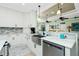 Modern kitchen with white cabinets, marble countertops, and a farmhouse sink at 13204 Kakapo Ave, Port Charlotte, FL 33981