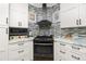 Modern kitchen with white cabinets, a corner range, and marble countertops at 13204 Kakapo Ave, Port Charlotte, FL 33981