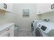 Laundry room with washer, dryer, and white cabinets at 13204 Kakapo Ave, Port Charlotte, FL 33981