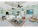 Bright living room with white sofas, ceiling fans, and decorative area rug at 13204 Kakapo Ave, Port Charlotte, FL 33981