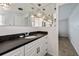 Bathroom with dark countertop, white cabinets, and crystal lighting at 1350 Aqua View Ln, Englewood, FL 34223