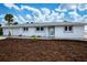 White single story home with gray roof, landscaping, and two-car garage at 1350 Aqua View Ln, Englewood, FL 34223