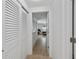 Hallway with white louvered doors and tile floor at 1350 Aqua View Ln, Englewood, FL 34223