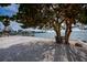 Relaxing waterfront patio area with bench under shade tree at 1350 Aqua View Ln, Englewood, FL 34223