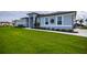 Gray house with walkway, landscaping, and palm trees at 15308 Acorn Cir, Port Charlotte, FL 33981