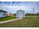 Gray storage shed with white trim and concrete walkway at 15308 Acorn Cir, Port Charlotte, FL 33981