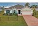 Front view of house with brick driveway and chain link fence at 16039 Quinta Dr, Punta Gorda, FL 33955