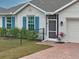 House exterior with blue shutters, landscaping, and brick driveway at 16039 Quinta Dr, Punta Gorda, FL 33955