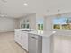 Modern kitchen with island, white cabinets, and view of backyard at 16039 Quinta Dr, Punta Gorda, FL 33955