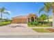 Tan two-story house with a three-car garage and lush landscaping at 1906 Creek Nine Dr, North Port, FL 34291