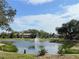 Peaceful pond with a fountain, lush landscaping, and beautiful Florida sky at 19505 Quesada Ave # Rr203, Port Charlotte, FL 33948