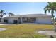 Single-story house with attached garage, light-colored exterior, and landscaped lawn at 2171 Bayou Rd, Punta Gorda, FL 33950