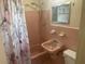 Bathroom with pink tile, shower/tub combo, and sink at 21921 Beverly Ave, Port Charlotte, FL 33952