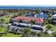 Aerial view of condo complex showcasing lake, parking, and building at 23465 Harborview Rd # 1006, Punta Gorda, FL 33980