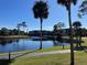 Peaceful lakefront view with a walking path and lush greenery at 23465 Harborview Rd # 1006, Punta Gorda, FL 33980