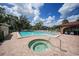 Inviting pool and spa area with brick patio at 23465 Harborview Rd # 1006, Punta Gorda, FL 33980