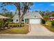 Gray house with green door, landscaping, and a long driveway at 238 Woodingham Trl, Venice, FL 34292