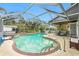 Inviting kidney-shaped pool with screened enclosure and patio furniture at 238 Woodingham Trl, Venice, FL 34292