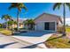 Tan house with a two car garage and lush landscaping at 24060 Buckingham Way, Punta Gorda, FL 33980