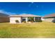 Tan house with screened porch and landscaped yard at 24060 Buckingham Way, Punta Gorda, FL 33980