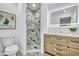 Modern bathroom with marble shower, lighted mirror, and wooden vanity at 2418 Frantz St, North Port, FL 34286