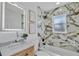 Modern bathroom with marble tile, a bathtub, and a lighted mirror at 2418 Frantz St, North Port, FL 34286