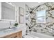 Updated bathroom featuring marble tile, a bathtub, and a sleek vanity at 2418 Frantz St, North Port, FL 34286