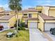 Bright yellow two-story townhome with attached garage and landscaping at 25188 Marion Ave # 1011, Punta Gorda, FL 33950