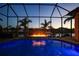 Inviting swimming pool and spa with a fire feature, screened enclosure, and waterfront view at 2521 Rio Grande Dr, Punta Gorda, FL 33950