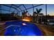 Blue-lit pool and spa at night with fire feature at 2521 Rio Grande Dr, Punta Gorda, FL 33950