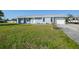 Newly renovated home with light blue exterior and a grassy yard at 282 Seminole Nw Blvd, Port Charlotte, FL 33952